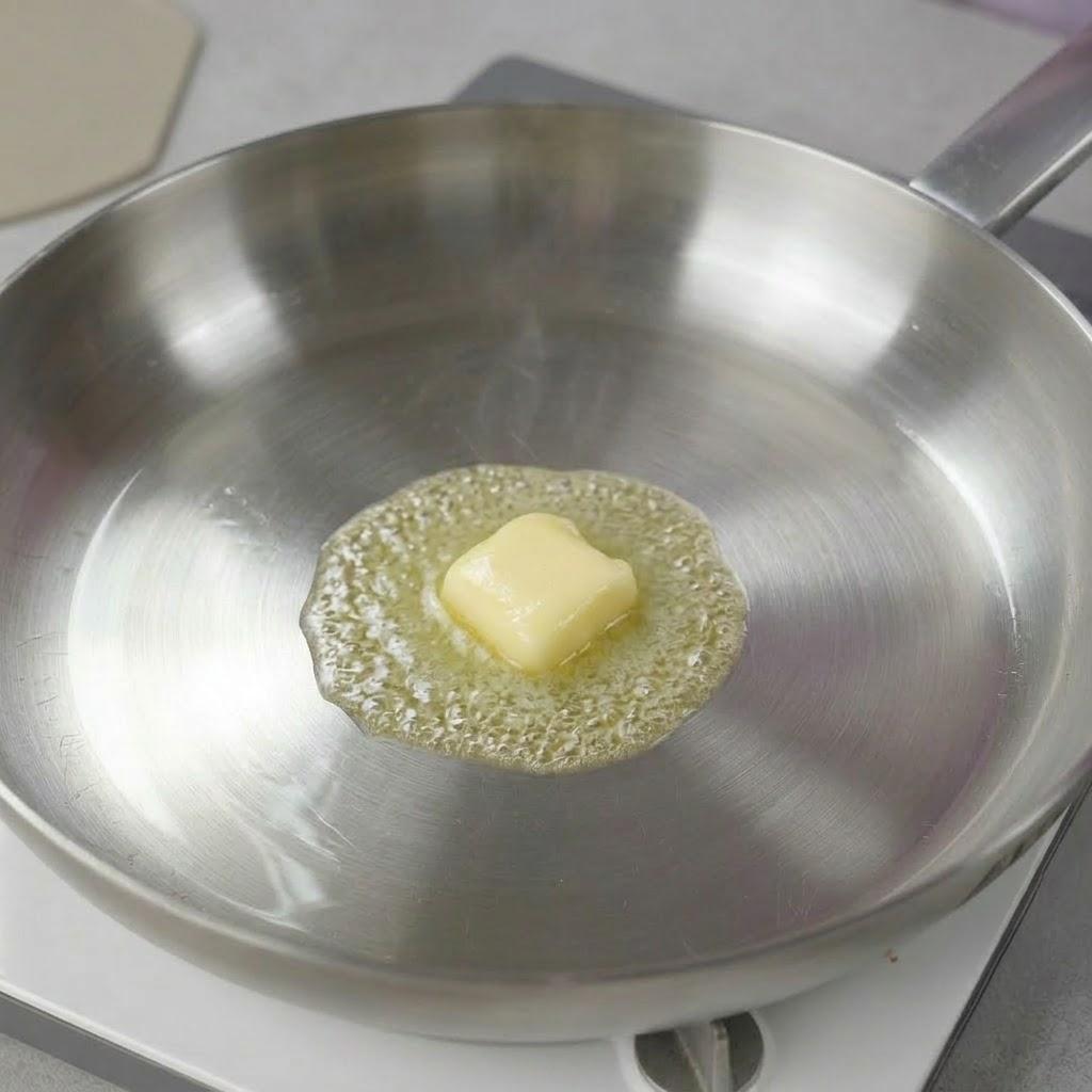 中火で熱したフライパンにバターまたはサラダ油を適量入れ、全体に行き渡るようになじませます。